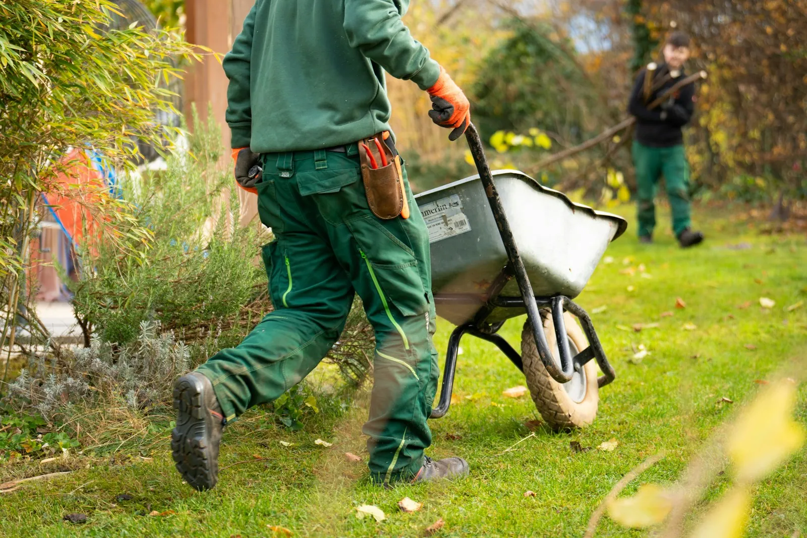 Gardeners at work with a wheelbarrow