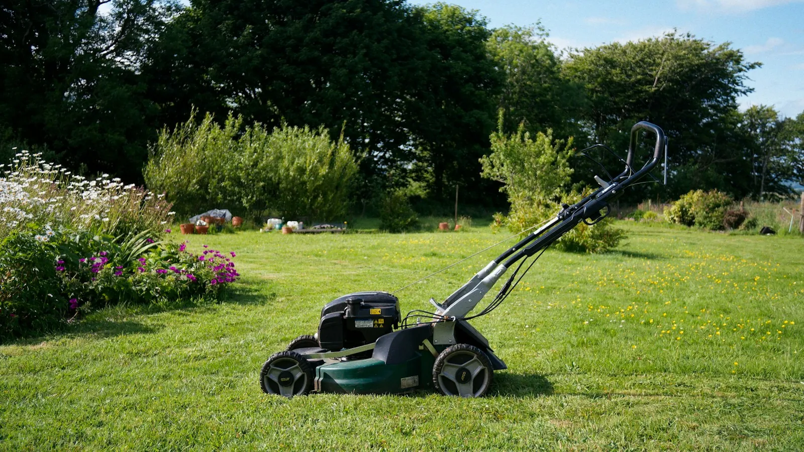 A lawn mower on a freshly cut garden lawn