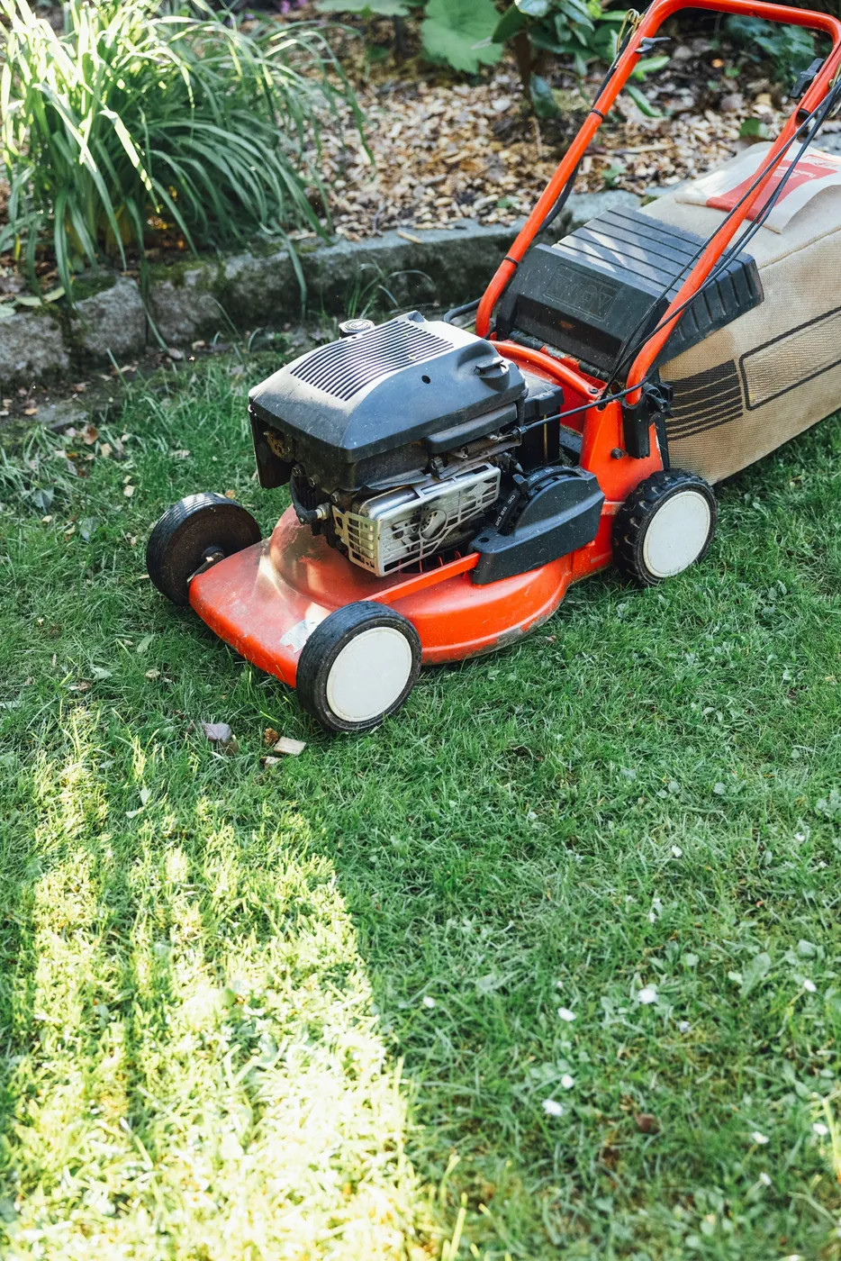 A red lawn mower on a fresh lawn