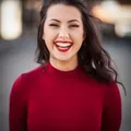 A smiling client in a red sweater