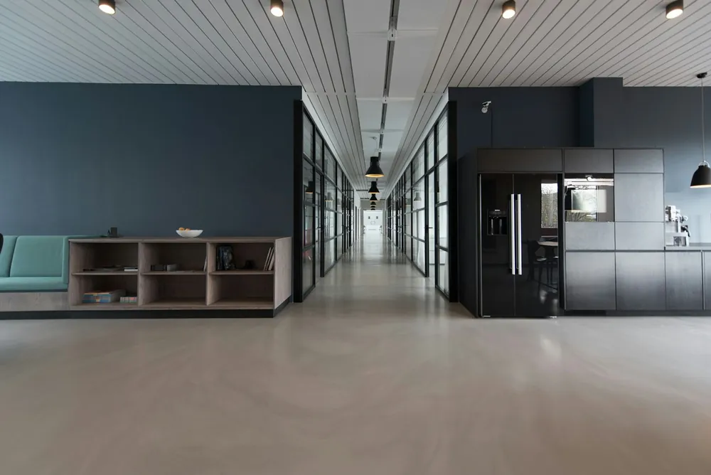 A quiet office corridor with a kitchen and shelves