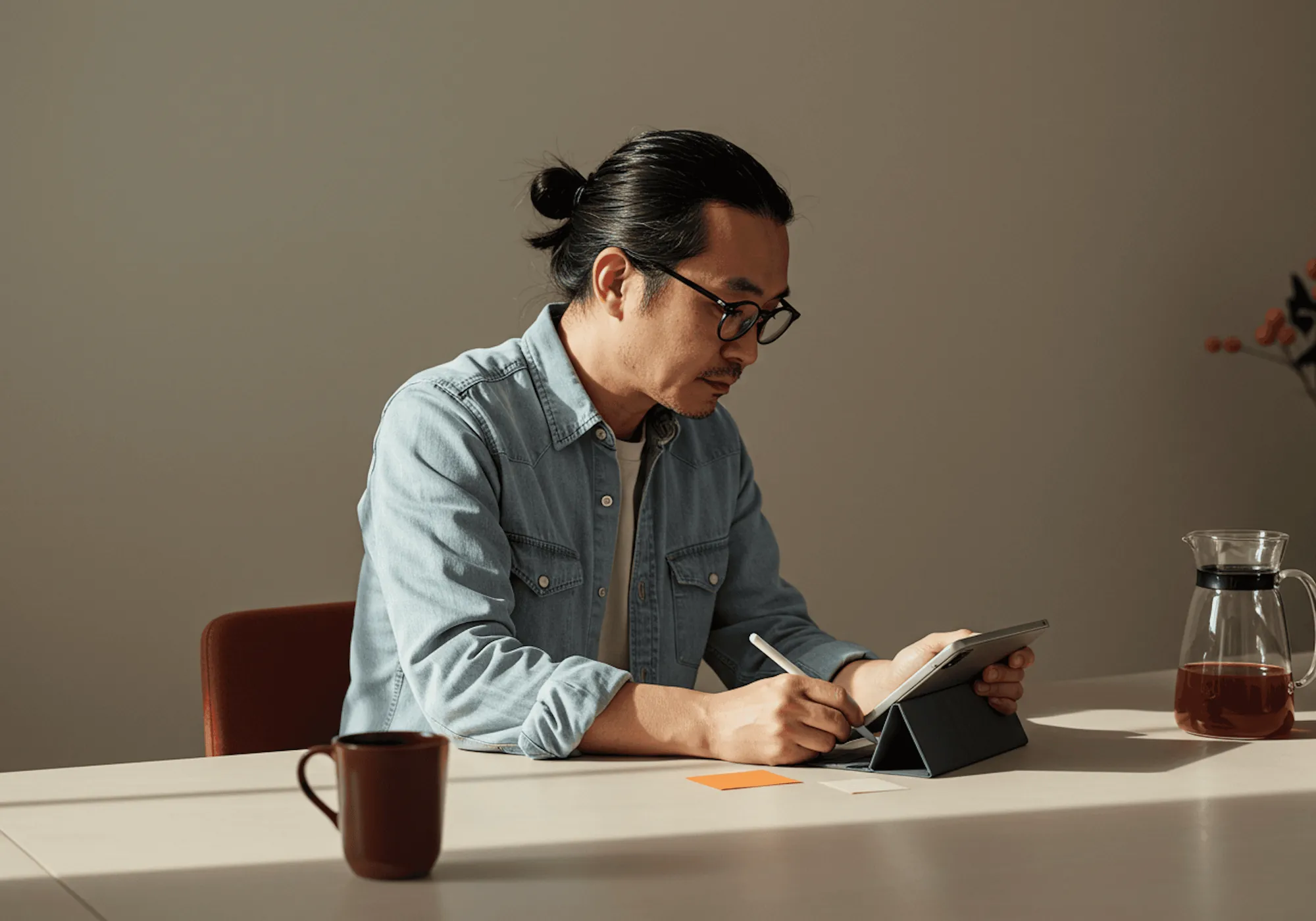 A founder with glasses taking notes at a desk