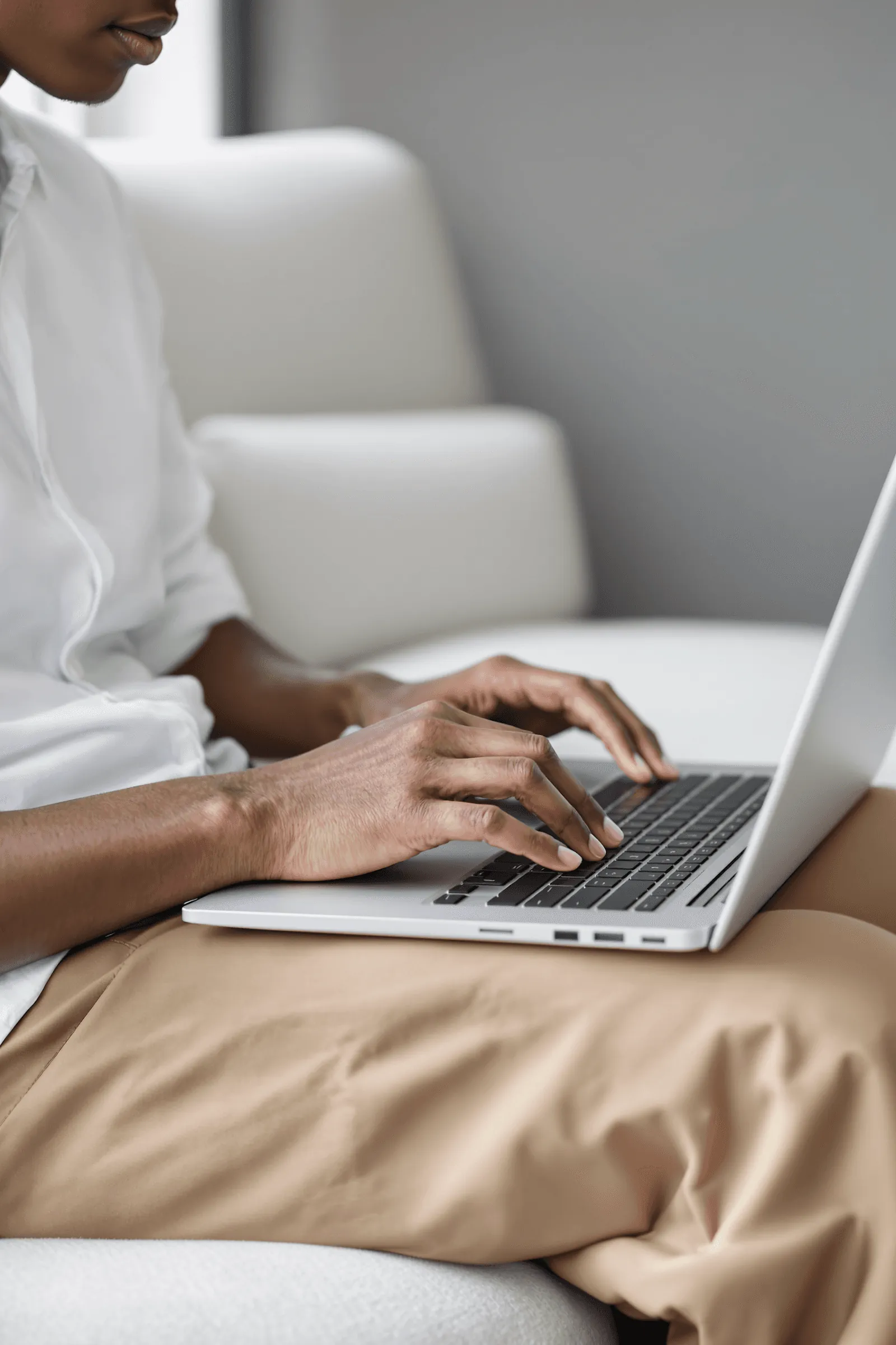 Close-up of hands typing on a laptop