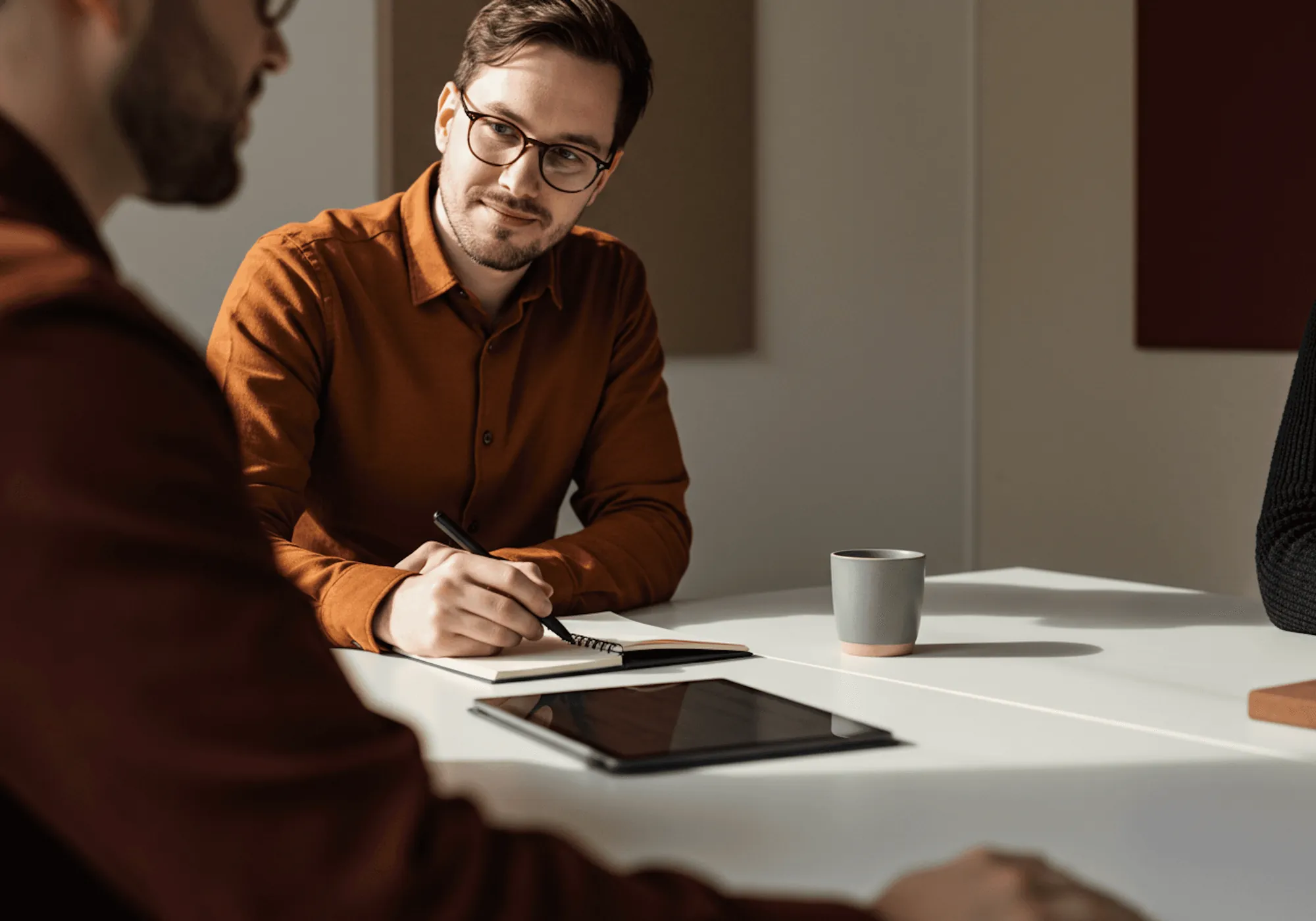 An advisor and a founder in a working session, one taking notes