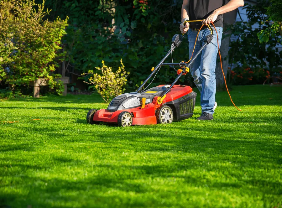 A red mower crossing a sunny lawn