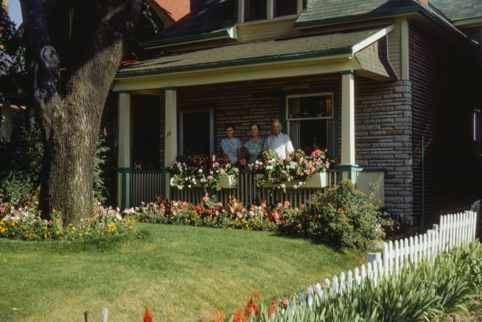 Family sitting on the porch of a well-kept home