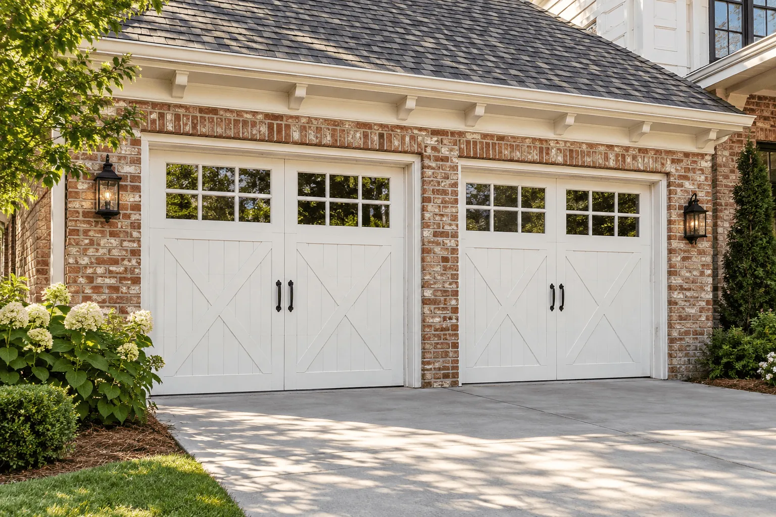 White carriage-house garage doors on a brick home