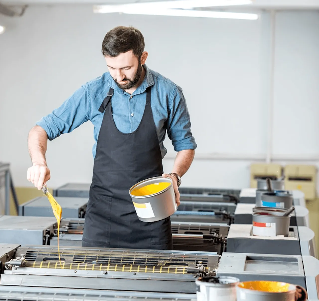 A craftsman pouring paint at a workbench