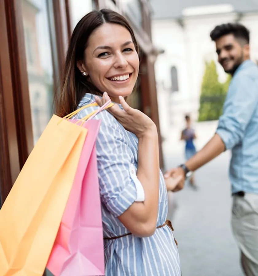 A woman with shopping bags greeting a friend
