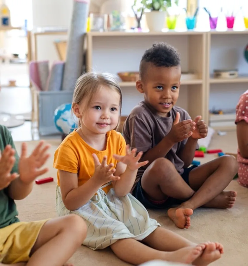 Toddlers clapping in a playroom