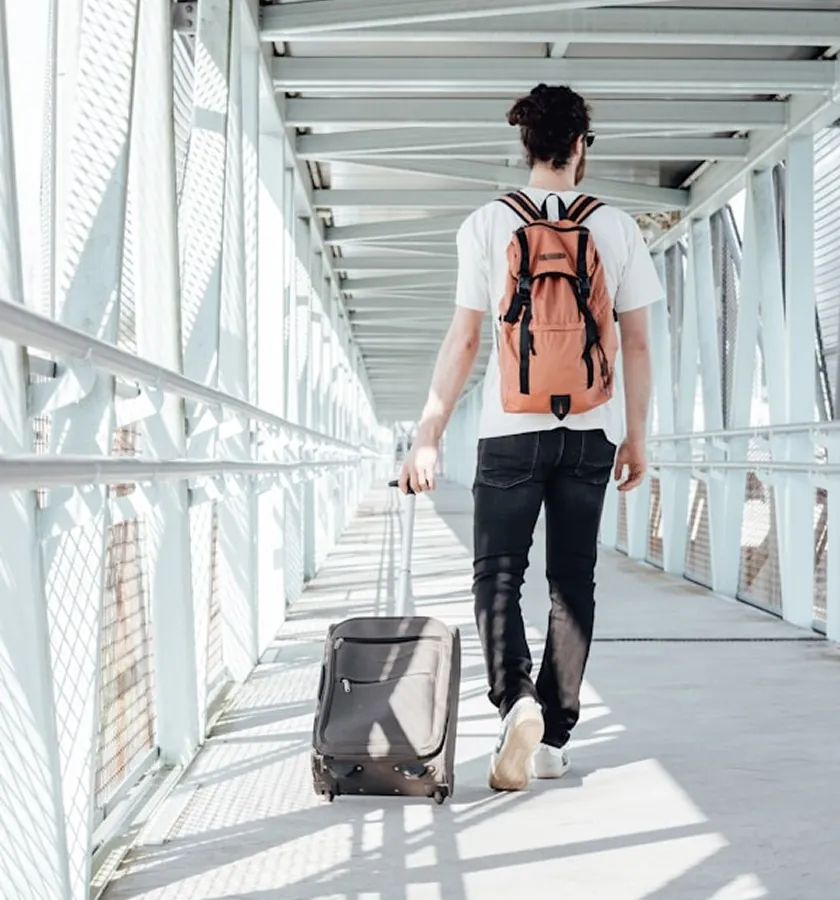 A traveller with a backpack and a suitcase