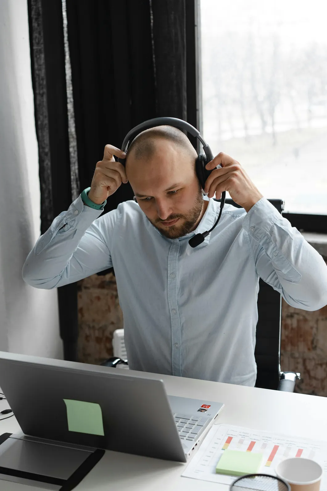 A consultant putting on a headset at his laptop