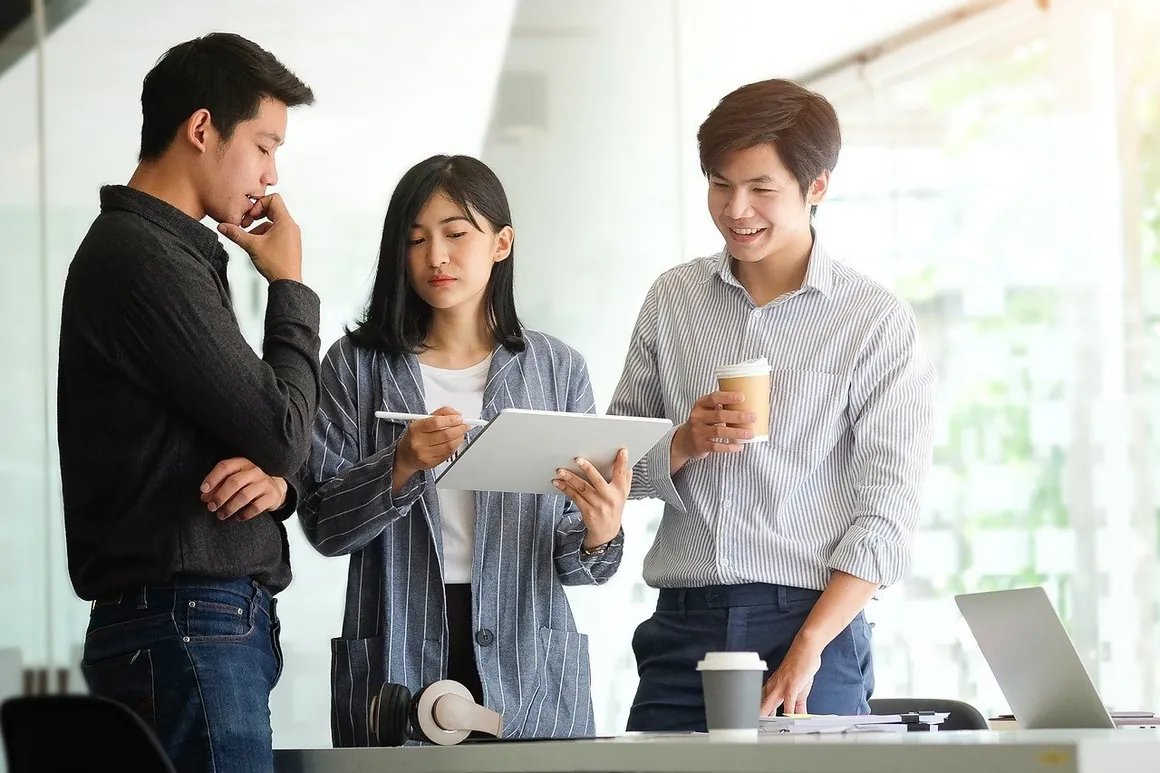 Three colleagues reviewing a plan on a tablet