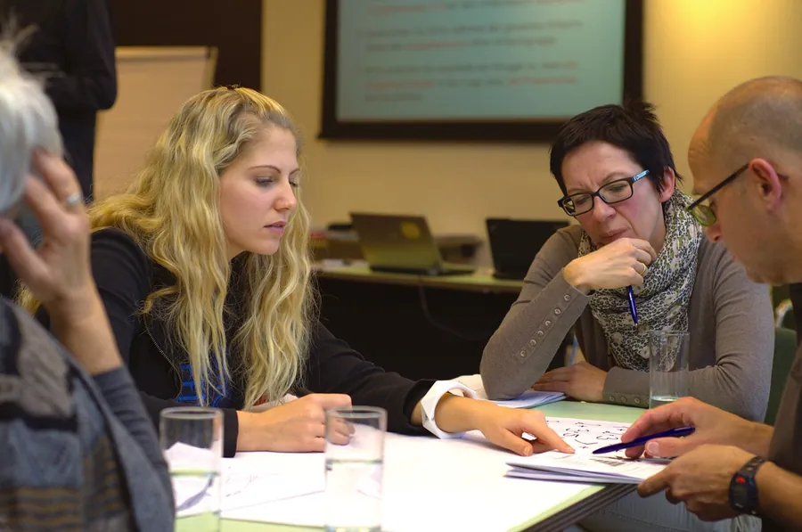 Consultants working out a strategy around a meeting table
