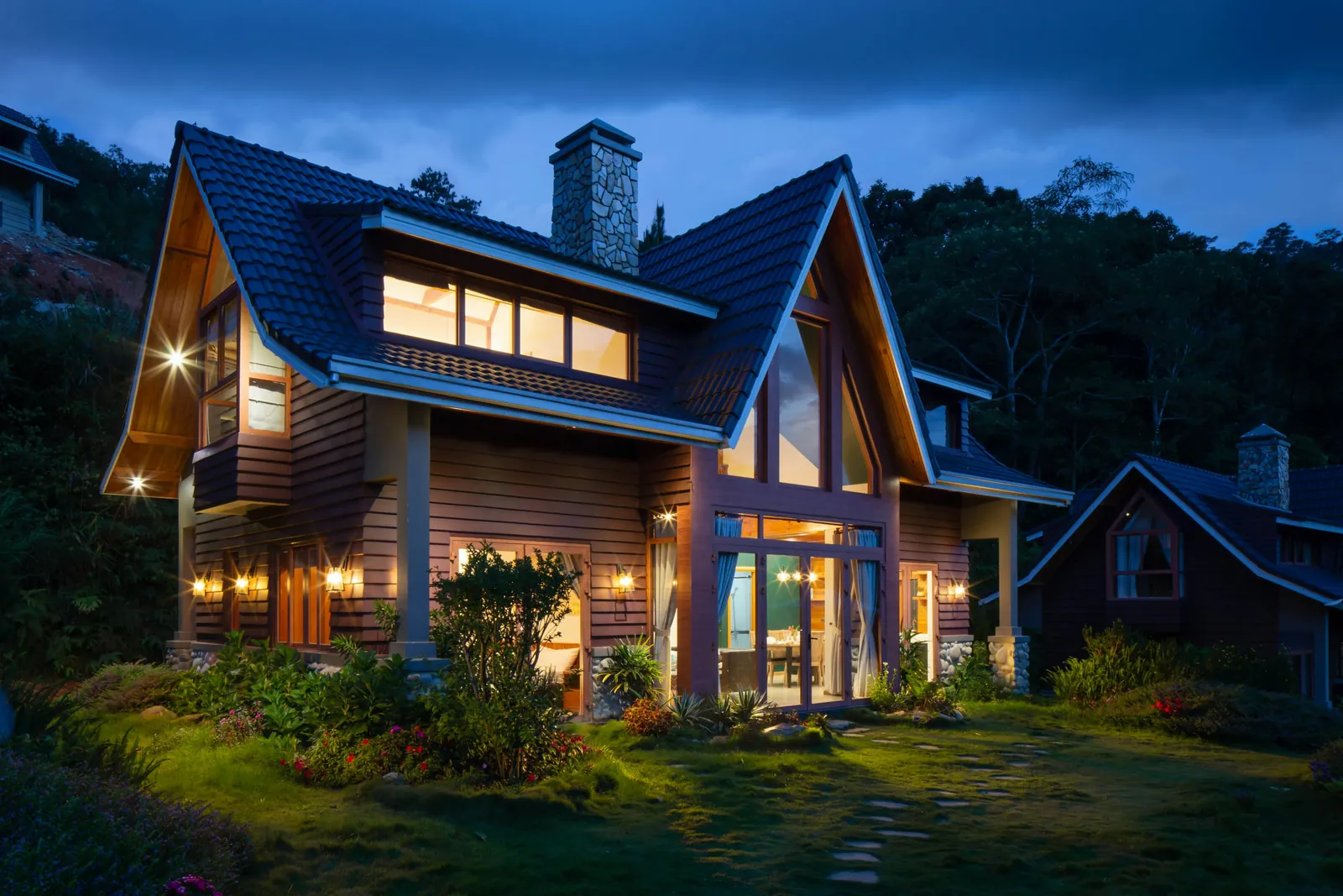 A timber family home lit up at dusk