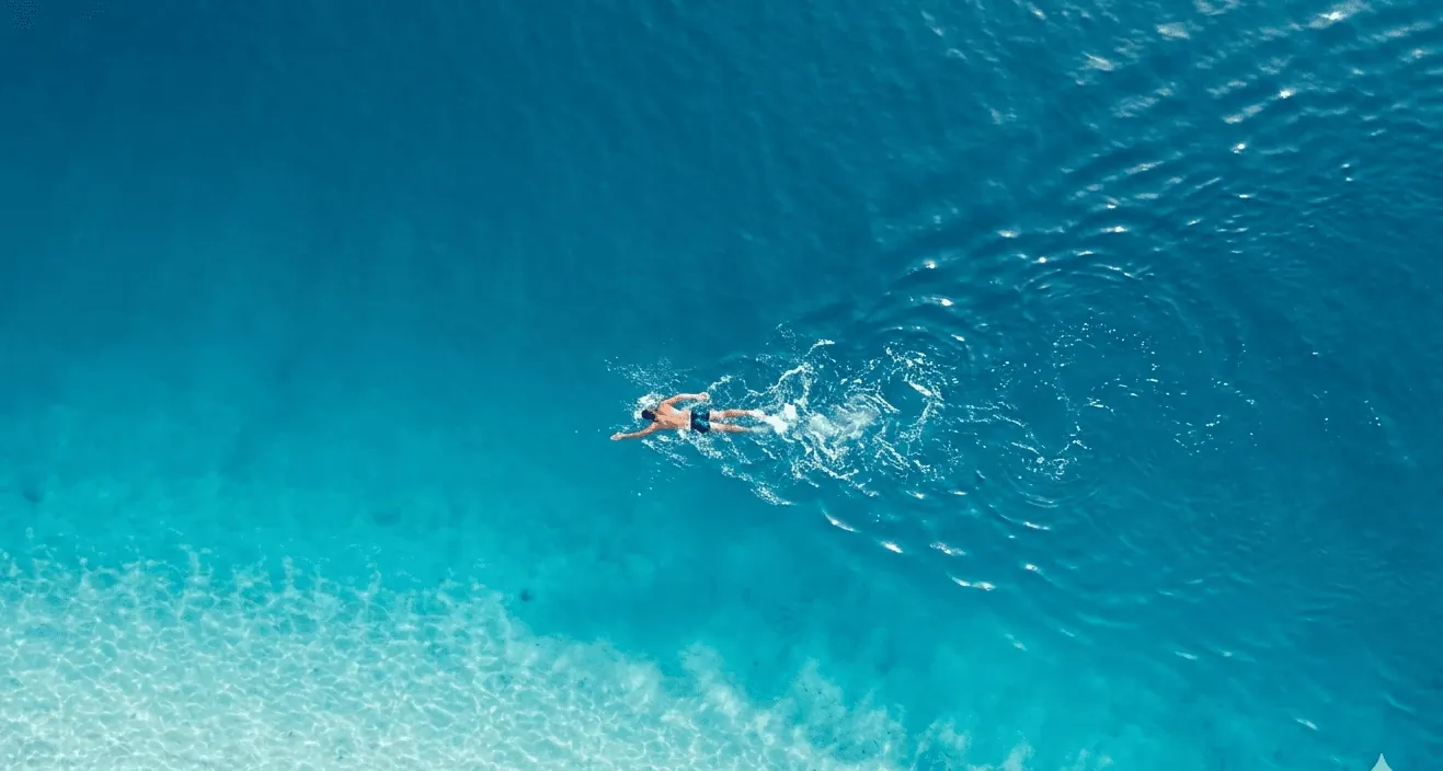 A person swimming in a turquoise ocean