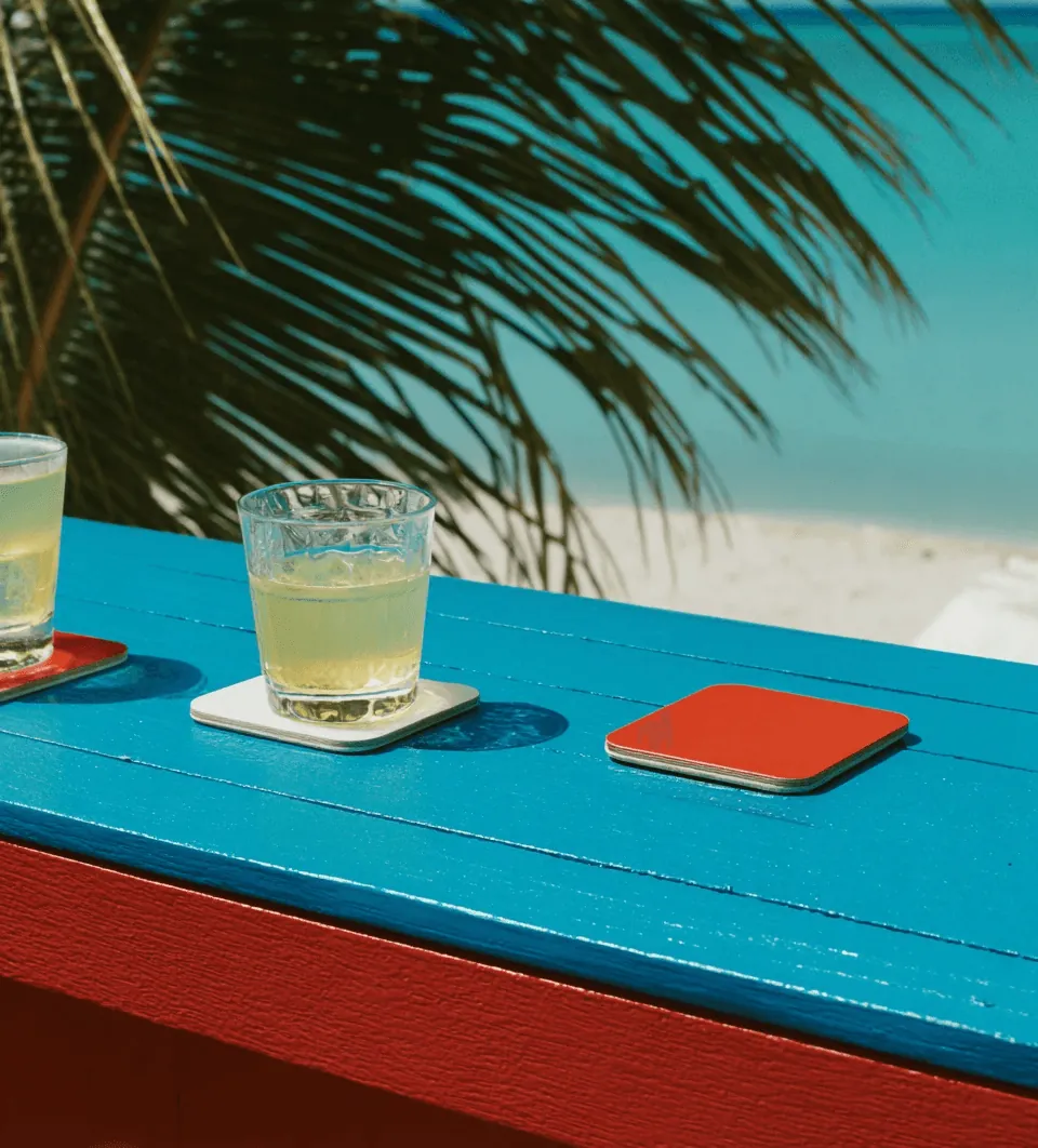 A cold drink on a blue table under palm leaves