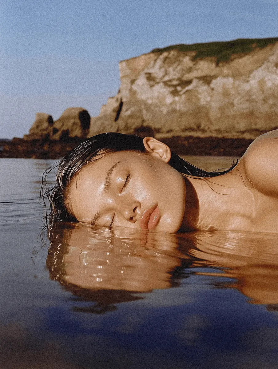 A woman floating in calm water with her eyes closed