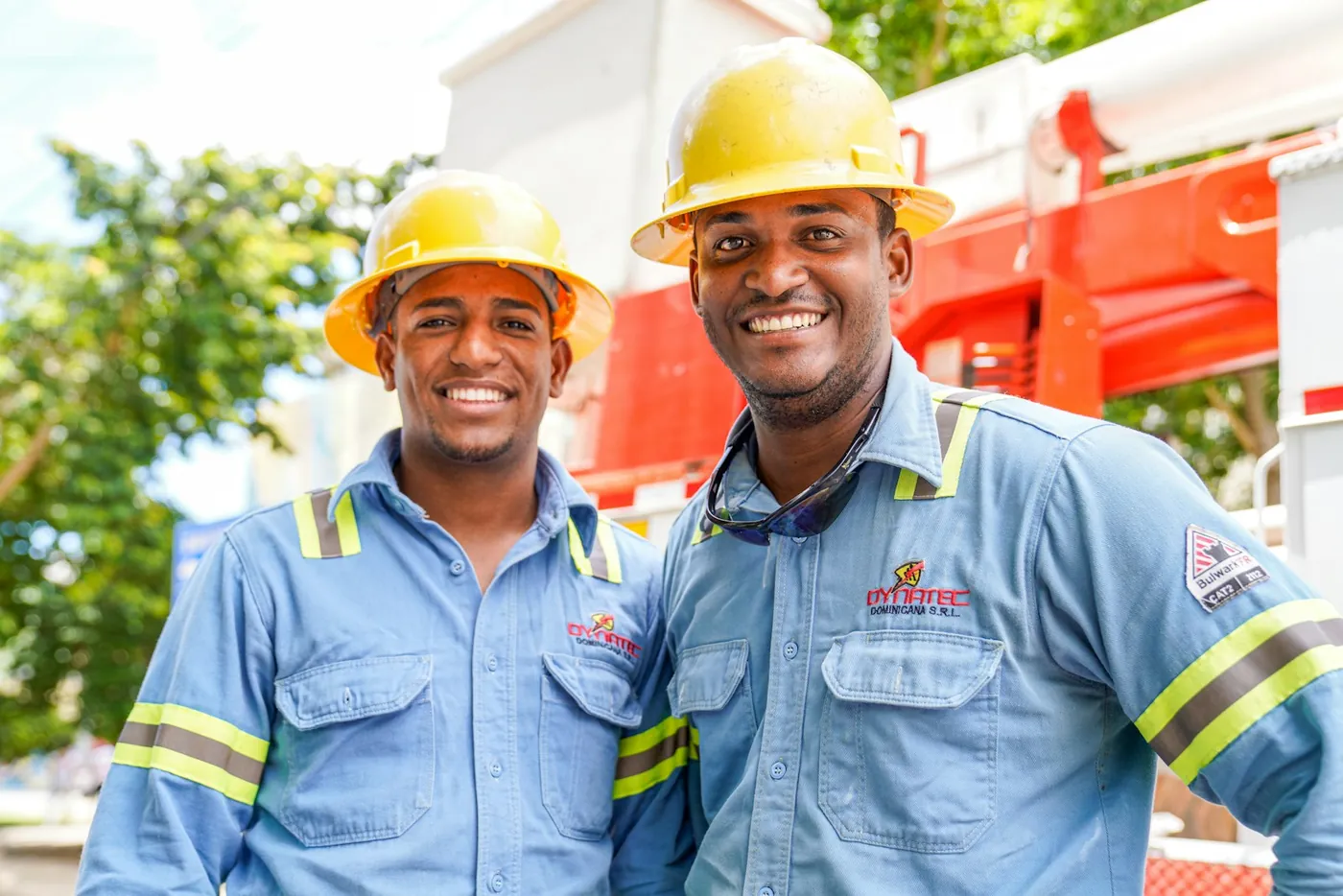 Two smiling crew members in blue work uniforms