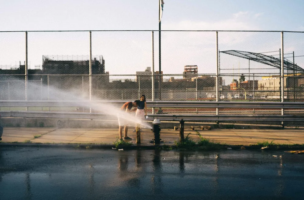 High-pressure water jet cleaning a paved surface