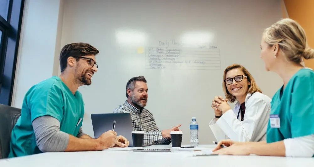 Colleagues smiling around a meeting table