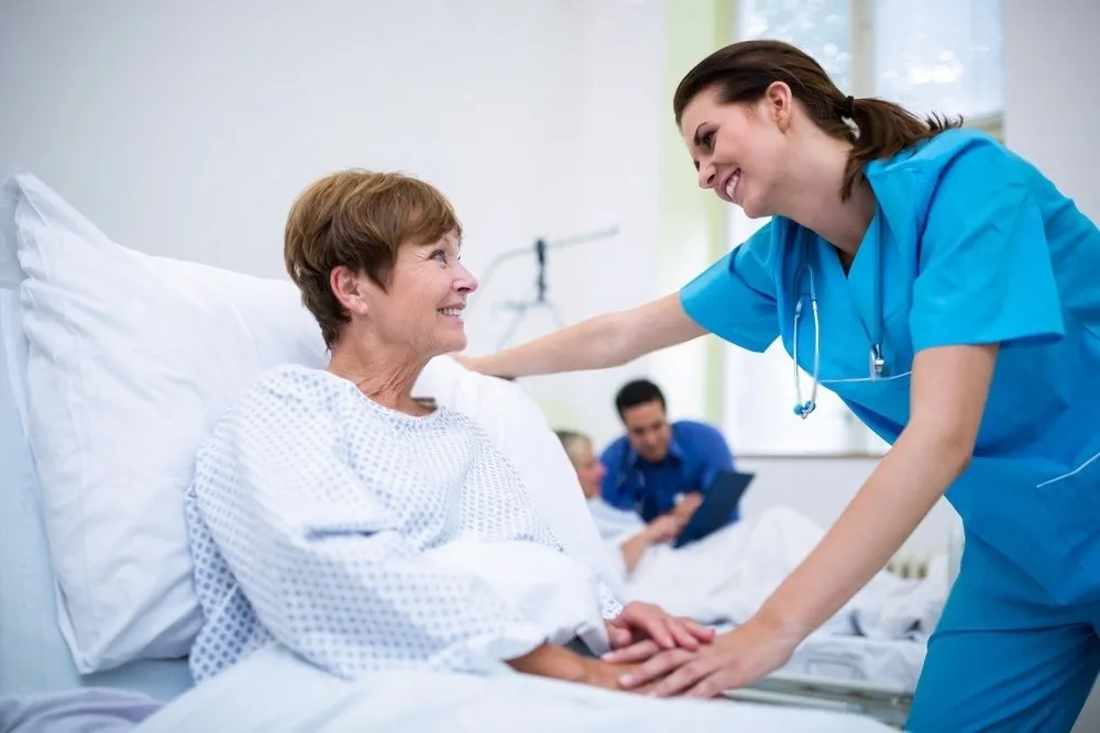 A nurse caring for a patient in bed